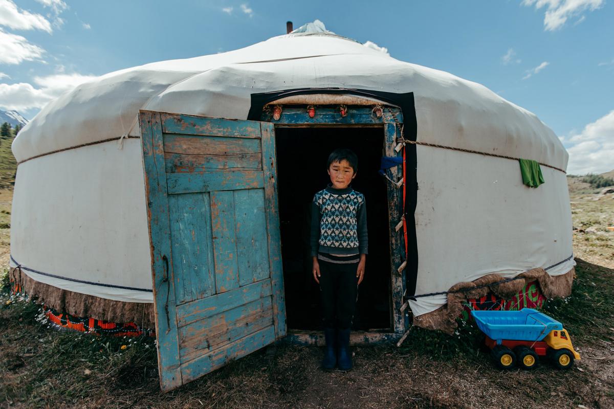 A boy in front of his yurt. 