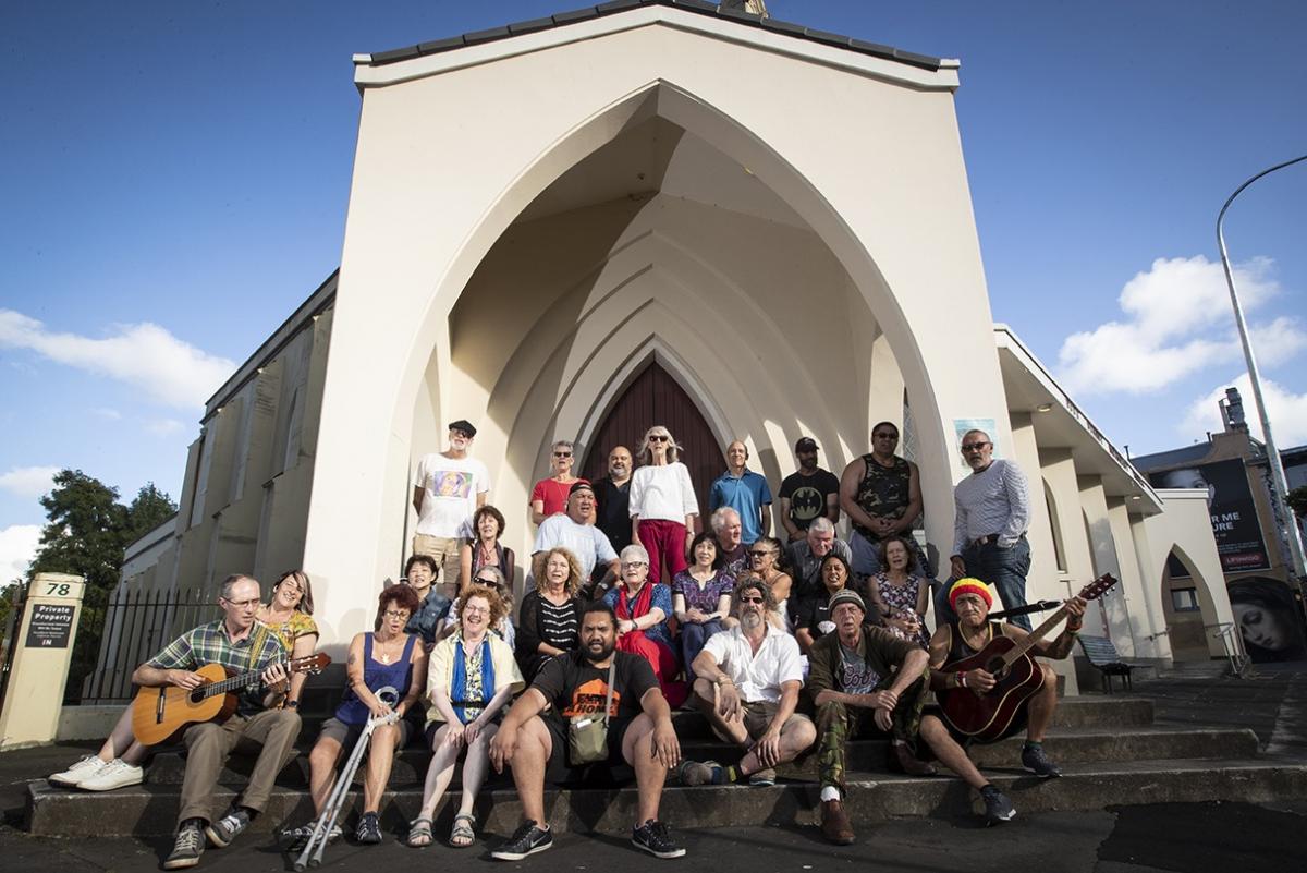 The Auckland Street Choir of around 30 members posing in front of the Pitt St Methodist Church