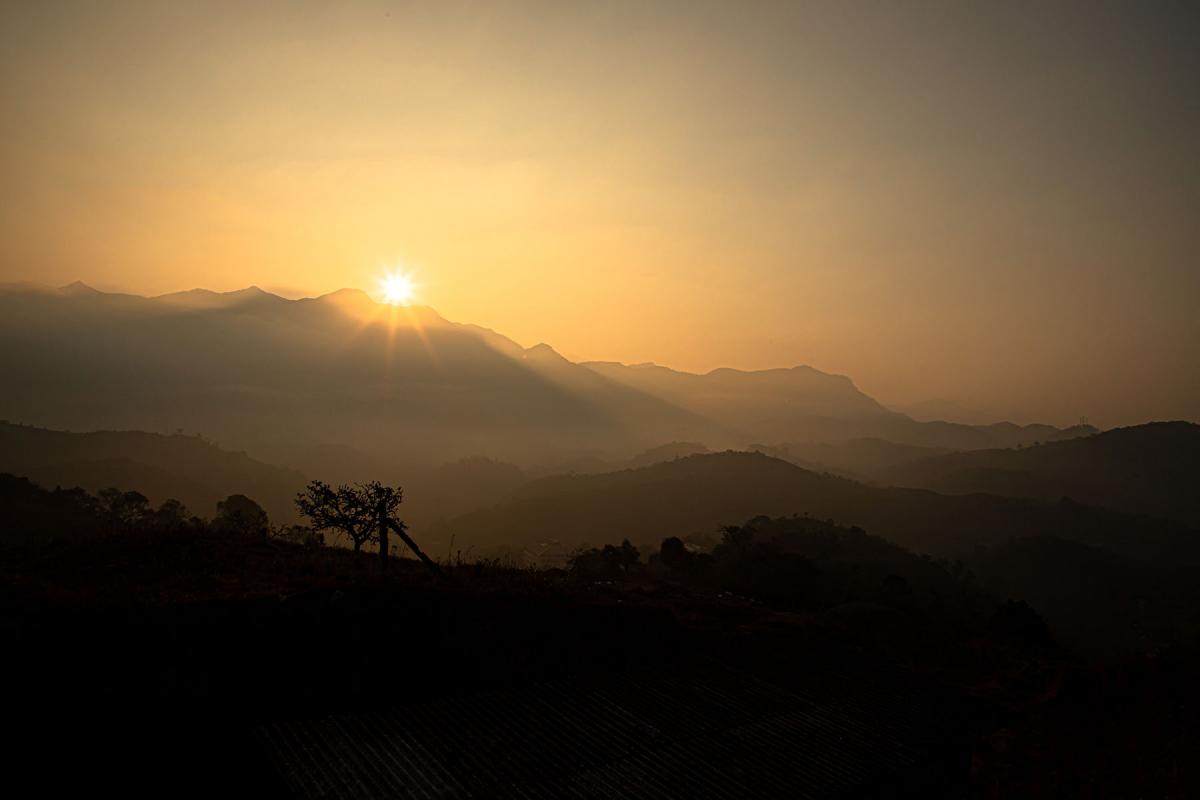 A sunset in Wayanad, Kerala, featuring the hills in the background